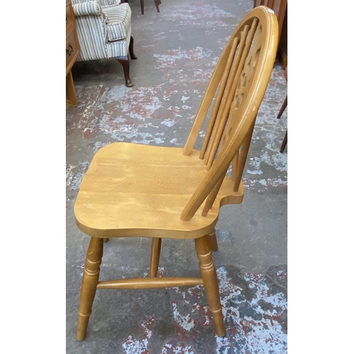 87 - Four beech wheelback dining chairs