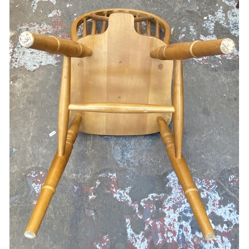 87 - Four beech wheelback dining chairs