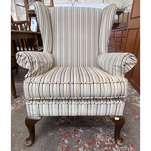 90 - A Victorian style fabric upholstered wingback armchair on cabriole supports