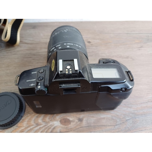 563 - Three Canon EOS 35mm SLR cameras, one 650 fitted with Sigma 28-200mm 1:3.8-5.6 zoom lens, one cased ... 