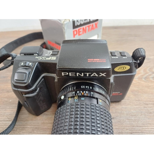 565 - Three Pentax 35mm SLR cameras, one SFXN autofocus fitted with Pentax-M 135mm 1:3.5 lens, one MZ-10 f... 