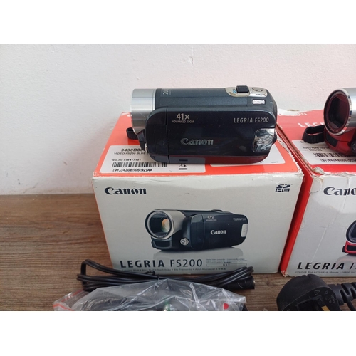 569 - Two boxed Canon Legria digital camcorders with software discs, accessories and instruction manuals, ... 