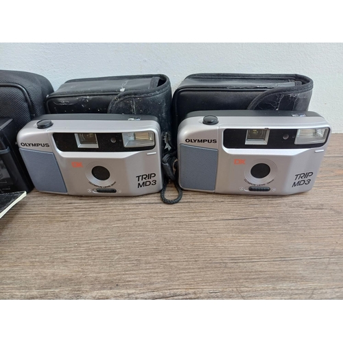 574 - Four cased Olympus Trip compact 35mm cameras, one AF MD with instruction manual, one AF S-2 and two ... 