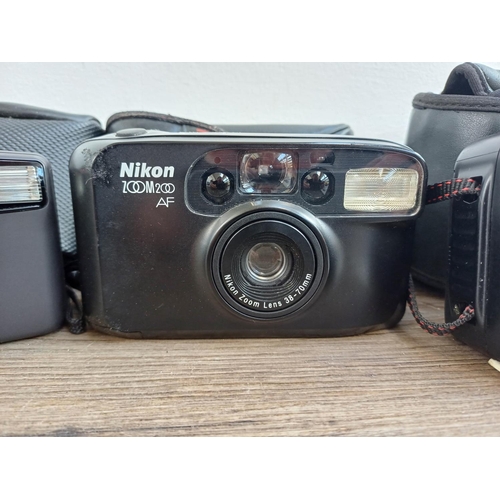 576 - Three cased Nikon compact autofocus 35mm cameras, one TW Zoom with instruction manual, one Zoom 500 ... 