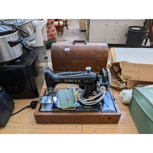 748 - A cased 1935 Singer 99K electric sewing machine with instruction manual and accessories