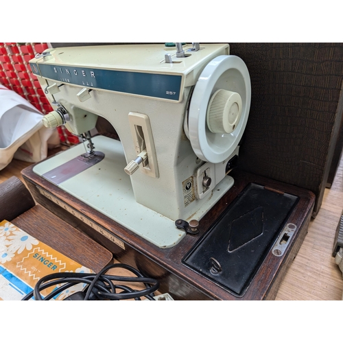 762 - A cased Singer 257 electric sewing machine with foot pedal, attachments and instruction manual