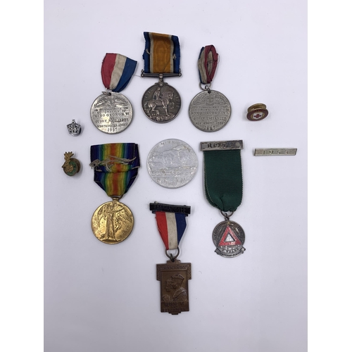 2167 - A collection of medals and badges to include WWI British medal pair presented to 35983 Pte. A. Mouls... 