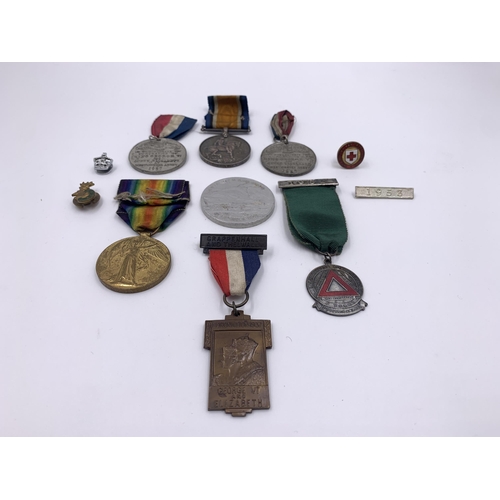 2167 - A collection of medals and badges to include WWI British medal pair presented to 35983 Pte. A. Mouls... 