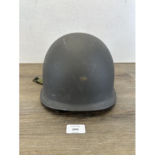 2203 - A Danish M48 M1 style civil defence helmet with CF stamp to interior and liner