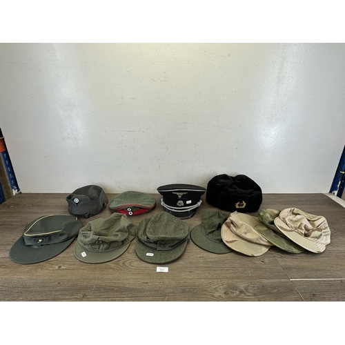 2212 - Eleven military caps to include reproduction WWII SS peaked cap, reproduction WWII German M43 field ... 