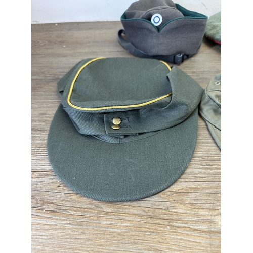 2212 - Eleven military caps to include reproduction WWII SS peaked cap, reproduction WWII German M43 field ... 