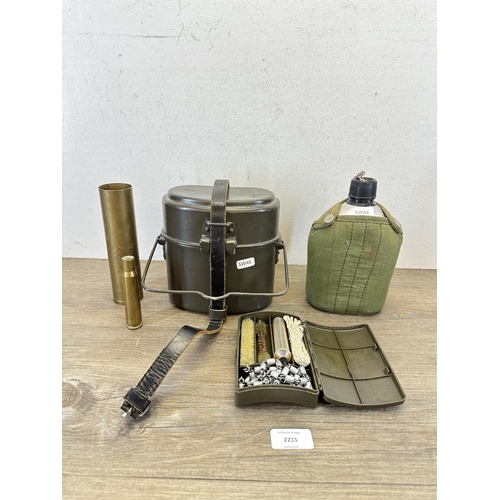 2215 - Five pieces of militaria to include WWII engraved shell case, rifle cleaning kit, canteen etc.