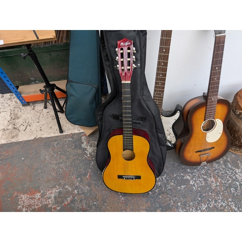 650 - Four musical instruments, one cased Music Alley child's nylon strung guitar, one Westwood stratocast... 