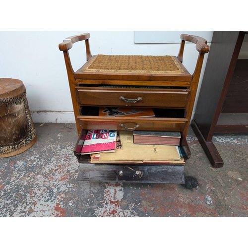 651 - An Edwardian wooden twin handled piano stool with three fall-front drawers with contents