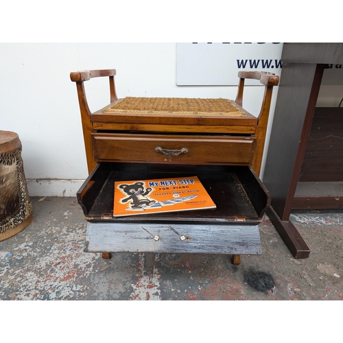 651 - An Edwardian wooden twin handled piano stool with three fall-front drawers with contents