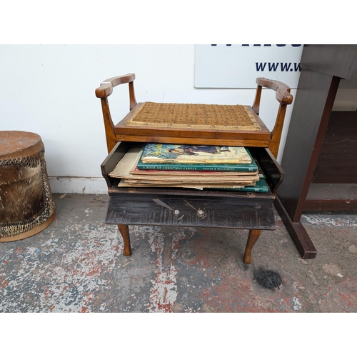 651 - An Edwardian wooden twin handled piano stool with three fall-front drawers with contents