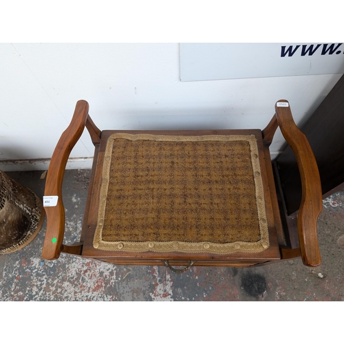 651 - An Edwardian wooden twin handled piano stool with three fall-front drawers with contents