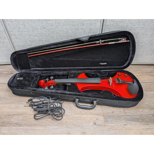 667 - A cased Zest electric violin with bow, cable, Snowpine rosin, spare bridge and in-ear headphones