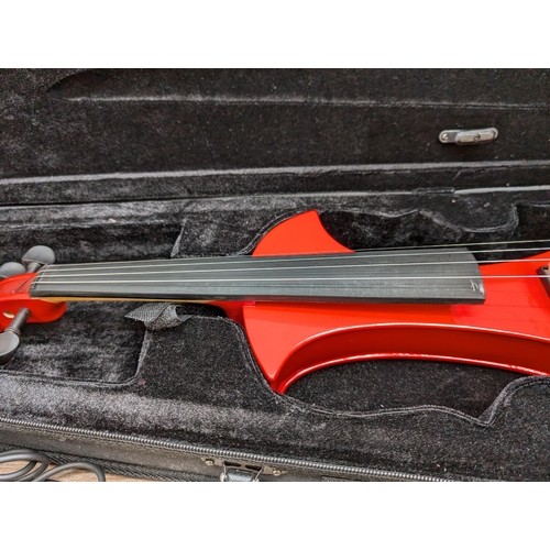 667 - A cased Zest electric violin with bow, cable, Snowpine rosin, spare bridge and in-ear headphones