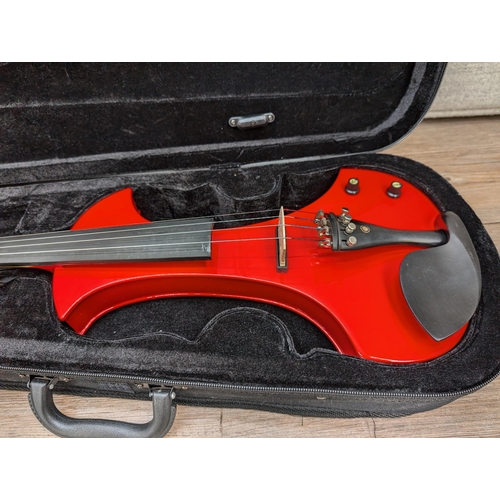 667 - A cased Zest electric violin with bow, cable, Snowpine rosin, spare bridge and in-ear headphones