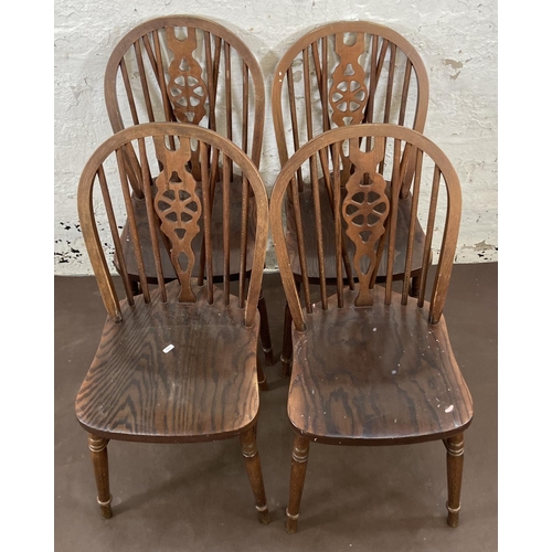 168 - Four beech wheelback dining chairs