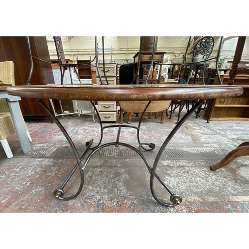 169 - A modern hardwood and wrought metal circular dining table and four chairs - approx. 76cm high x 136c... 