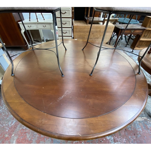 169 - A modern hardwood and wrought metal circular dining table and four chairs - approx. 76cm high x 136c... 