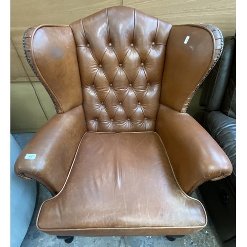 253 - A brown leather Chesterfield wingback armchair on cabriole supports