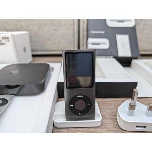 727 - A collection of Apple items to include three Apple TV streaming devices, iPod Nano 4th generation, b... 