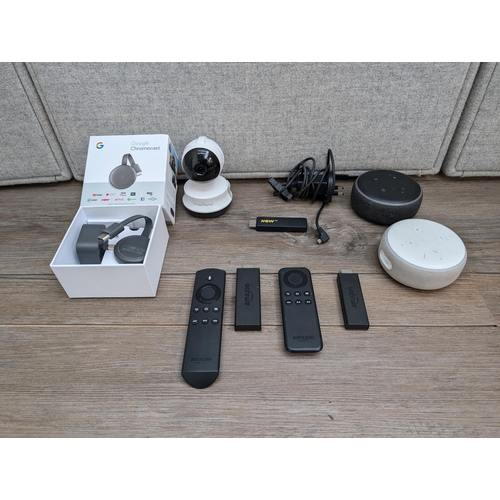 732 - A collection of home electronics to include two Amazon Fire sticks, boxed Google Chromecast, two Ama... 