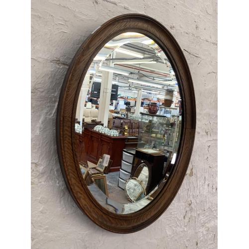 334 - Two wall mirrors, one early 20th century oak framed bevelled edge oval and one Regency style convex ... 