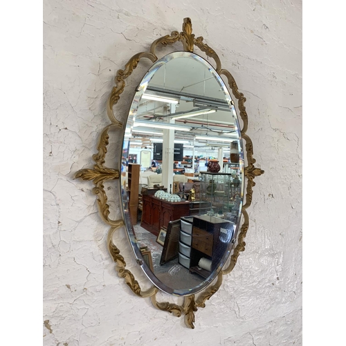 343 - Two mid 20th century oval wall mirrors, one oak framed bevelled edge and one French style metal fram... 