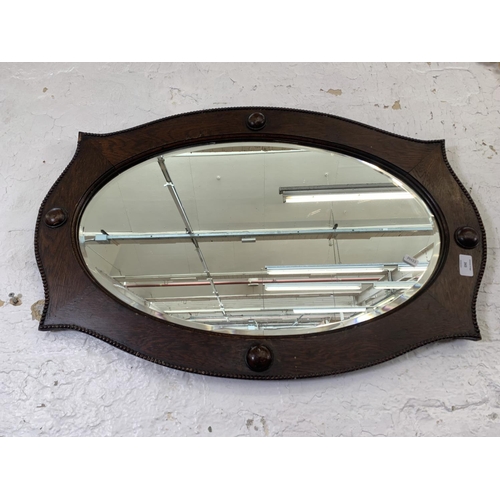 343 - Two mid 20th century oval wall mirrors, one oak framed bevelled edge and one French style metal fram... 