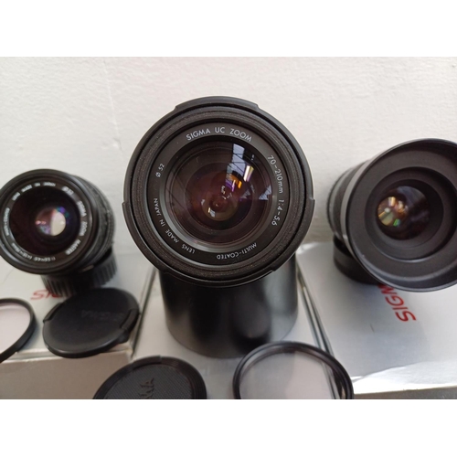 634 - Three Nikon 35mm SLR camera bodies and three boxed Sigma lenses for Nikon, one F-301 and two F55 bod... 