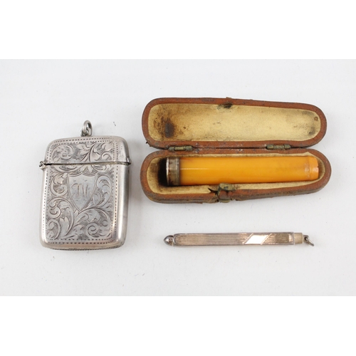 2191 - Three hallmarked sterling silver items, one vesta case, one toothpick and one cased amber cheroot ho... 