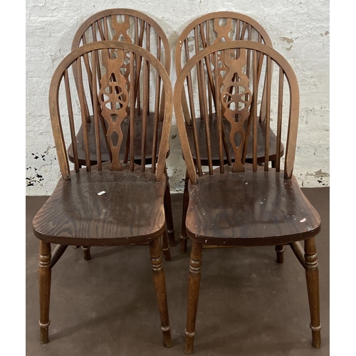 53 - Four beech wheelback dining chairs