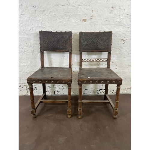 97 - A pair of Cromwellian style carved beech and brown leather dining chairs