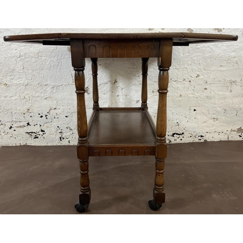 160 - A mid 20th century oak drop leaf two tier tea trolley