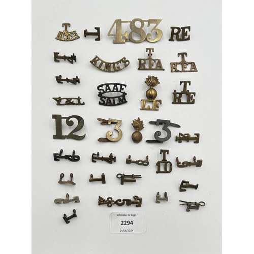 2294 - A collection of military shoulder titles and collar badges