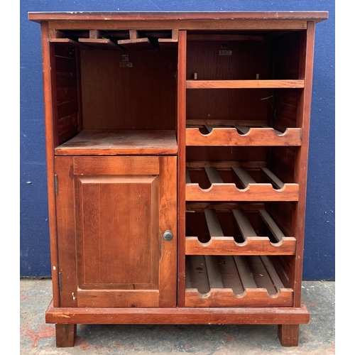 136 - A modern stained pine drinks cabinet with bottle rack - approx. 85cm high x 67cm wide x 36cm deep