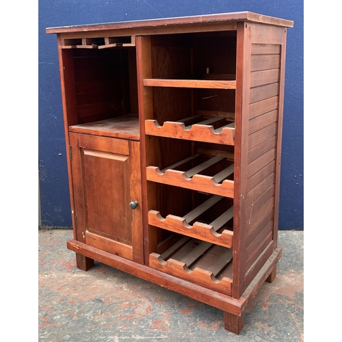 136 - A modern stained pine drinks cabinet with bottle rack - approx. 85cm high x 67cm wide x 36cm deep