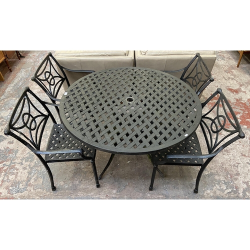 61 - A black painted cast metal five piece patio set comprising circular table and four chairs - table ap... 