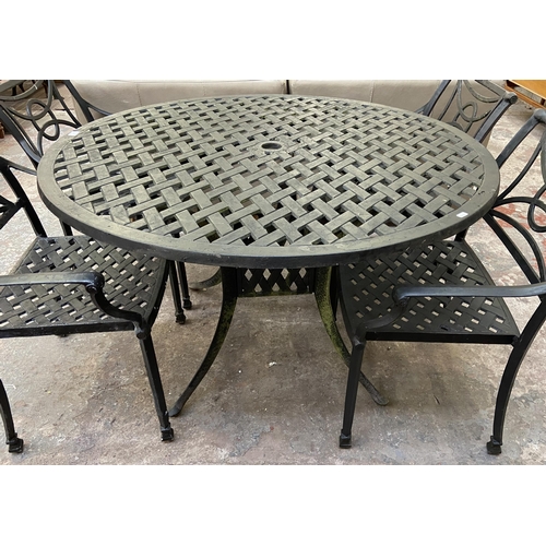 61 - A black painted cast metal five piece patio set comprising circular table and four chairs - table ap... 