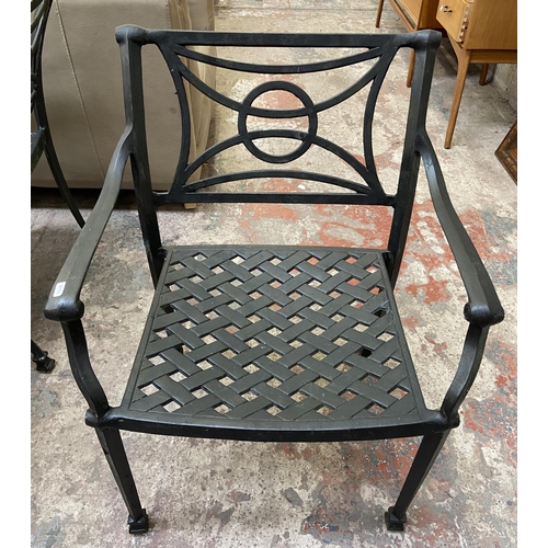 61 - A black painted cast metal five piece patio set comprising circular table and four chairs - table ap... 