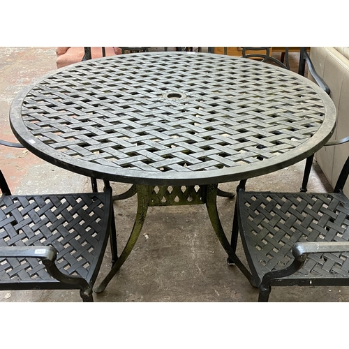 61 - A black painted cast metal five piece patio set comprising circular table and four chairs - table ap... 