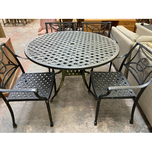 61 - A black painted cast metal five piece patio set comprising circular table and four chairs - table ap... 