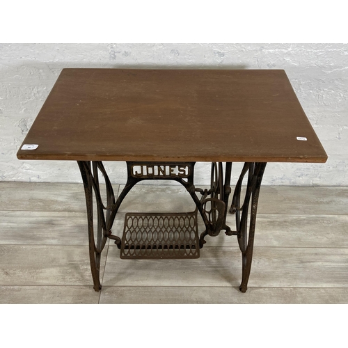 64 - A late 19th/early 20th century Jones cast iron treadle sewing machine base converted table - approx.... 