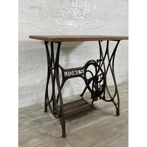 64 - A late 19th/early 20th century Jones cast iron treadle sewing machine base converted table - approx.... 