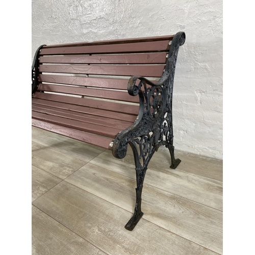 69 - A cast iron and wooden slatted two seater garden bench - approx. 72cm high x 110cm wide x 58cm deep