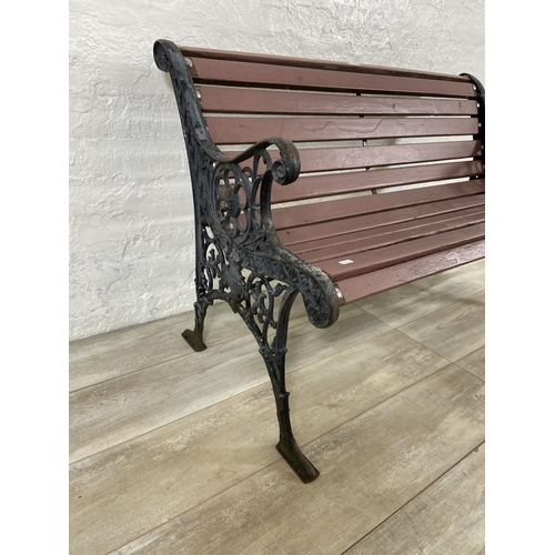 69 - A cast iron and wooden slatted two seater garden bench - approx. 72cm high x 110cm wide x 58cm deep